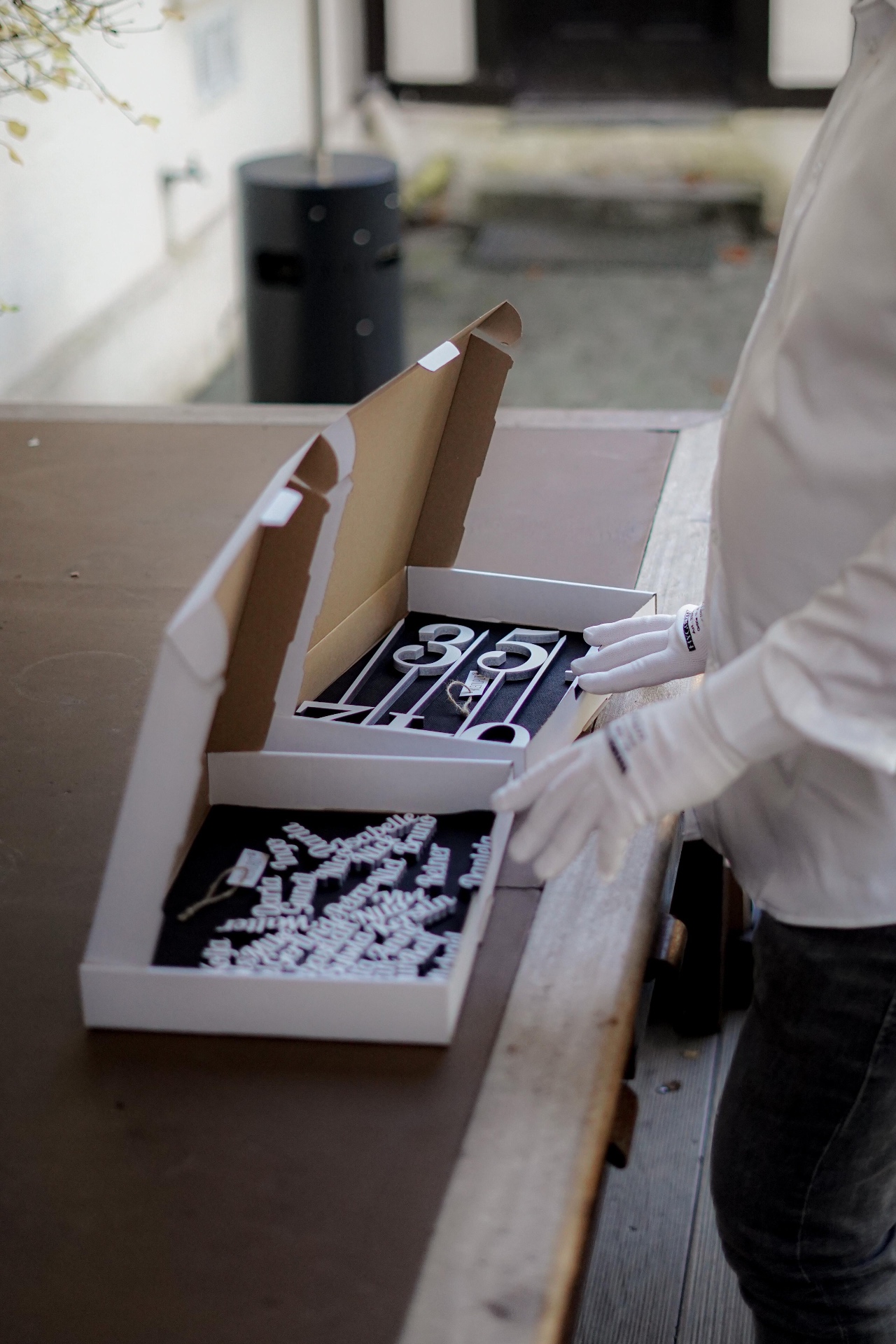 Lasergeschnittene Hausnummern und Namensschilder in Verpackung