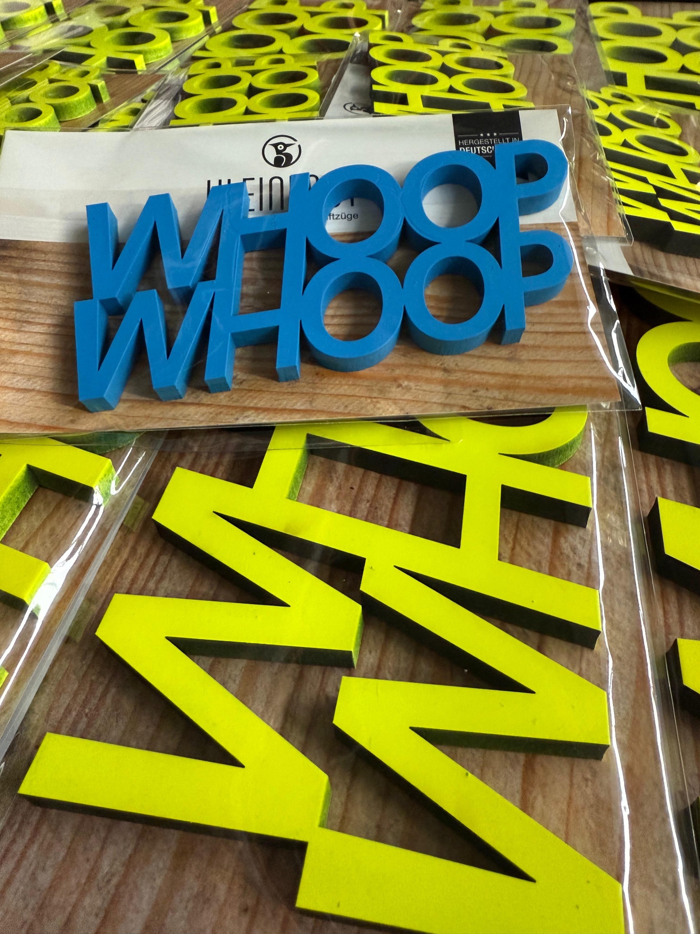 Lasergeschnittene Schriftzüge in Blau und Neongelb